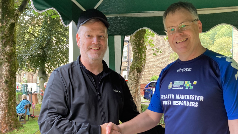 Member of public Carl shaking hands with Community First Responder Volunteer Andrew who saved his life.