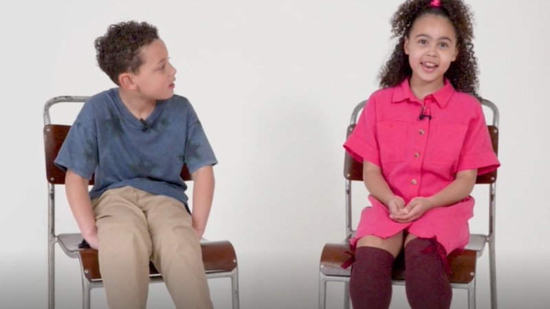 Two children sitting on chairs answering questions on the ambulance service