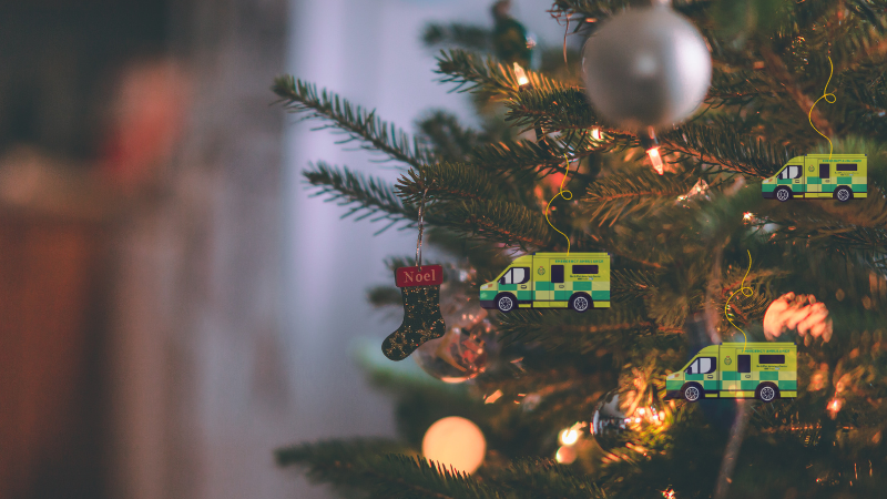 A Christmas tree with baubles and lights on it and hanging ambulance baubles. Text reads 'Christmas well-wish appeal.'