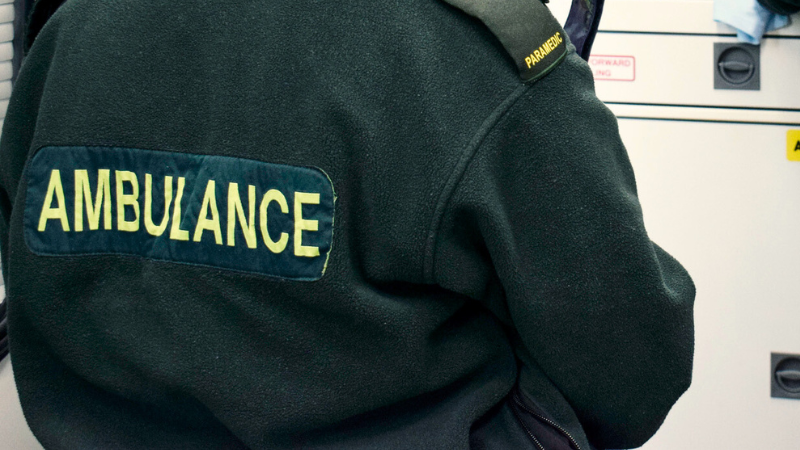 back of a green uniform with the word 'ambulance'