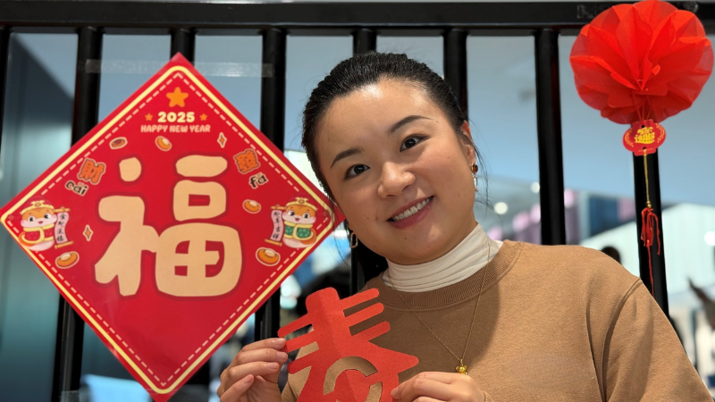 A person holding a Chinese New Year decoration.