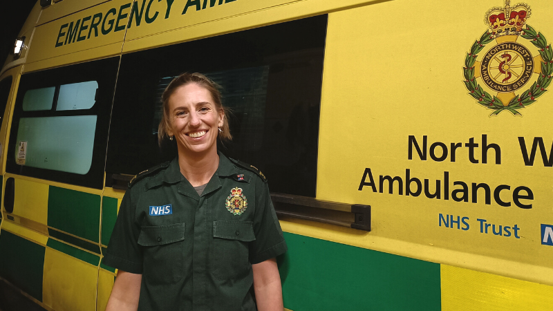 Gabby Dickinson standing in front of an ambulance